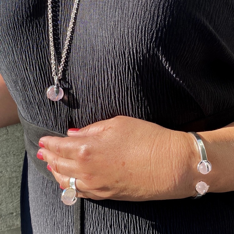Kvinna med matchande armband, hänge, och ring med rosenkvarts. Woman with matching ring, pendant and bracelet with rose quartz