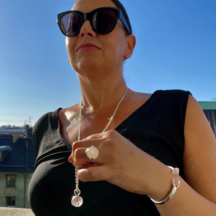 Kvinna med matchande armband, hänge, ring och örhängen med rosenkvarts. Woman with matching earrings, ring, pendant and bracelet with rose quartz