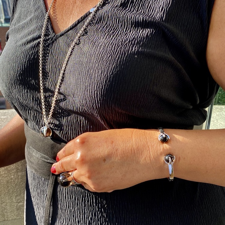 Kvinna med matchande armband, hänge och ring med rökkvarts. Woman with matching ring, pendant and bracelet with smokey quartz