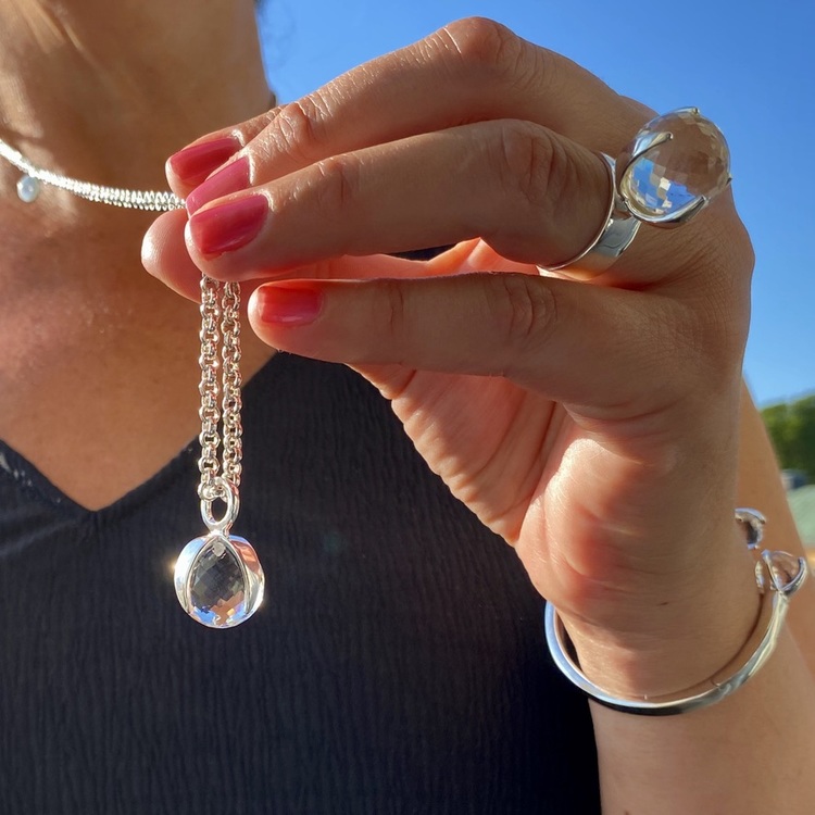Kvinna med matchande armband, hänge och ring  med bergskristall. Woman with matching ring, pendant and bracelet with crystal quartz