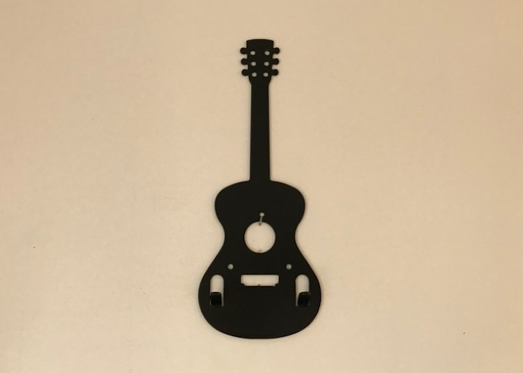 Svart hängare i form av en gitarr med två stycken krokar.