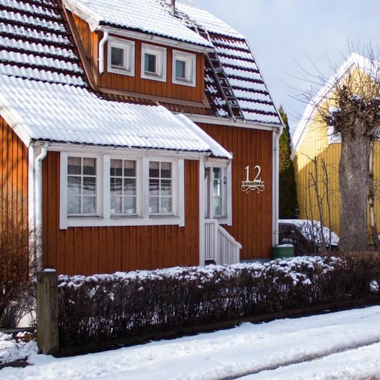 Hus med snygg husnummerskylt med egen text.