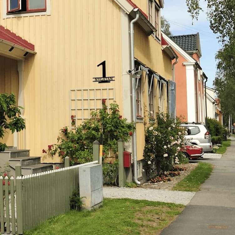 Stilren fasadsiffra med gatunamn.