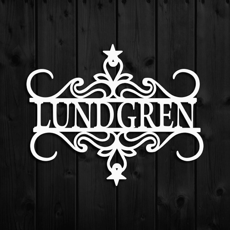 Vit väggdekor i metall, med namnet Lundgren.