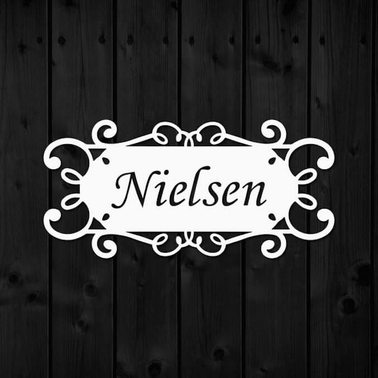 Namnskylt i metall med namnet Nielsen utskuret.