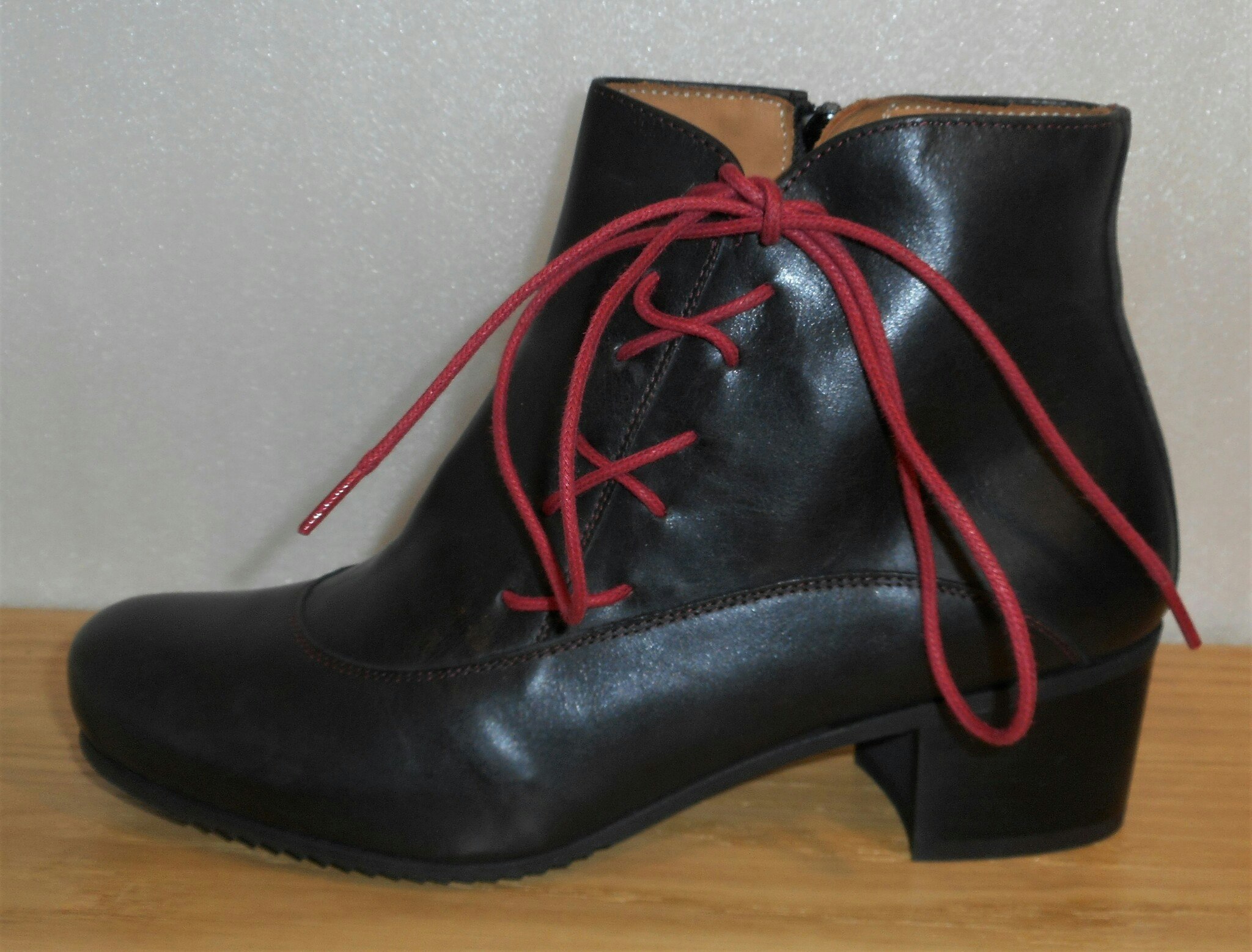 Svart boots med röd dekorsnörning på utsidan - Amberone
