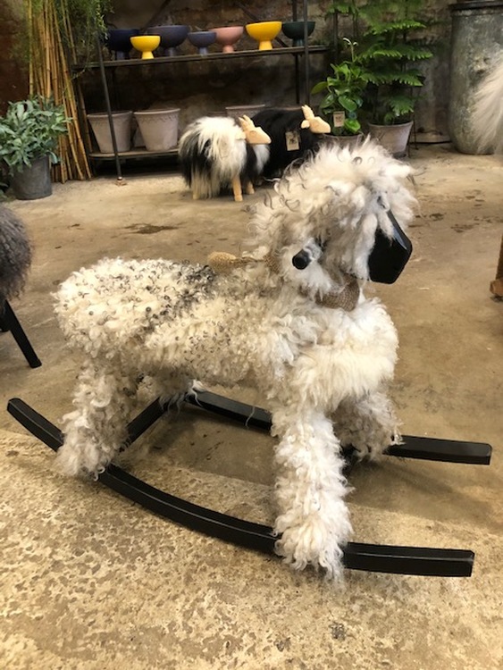 Rocking sheep with curled, lightgrey sheepskin . Woodwork painted in black