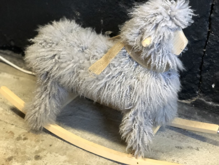 Rocking sheep with lightgrey sheepskin. Woodwork in natural colours