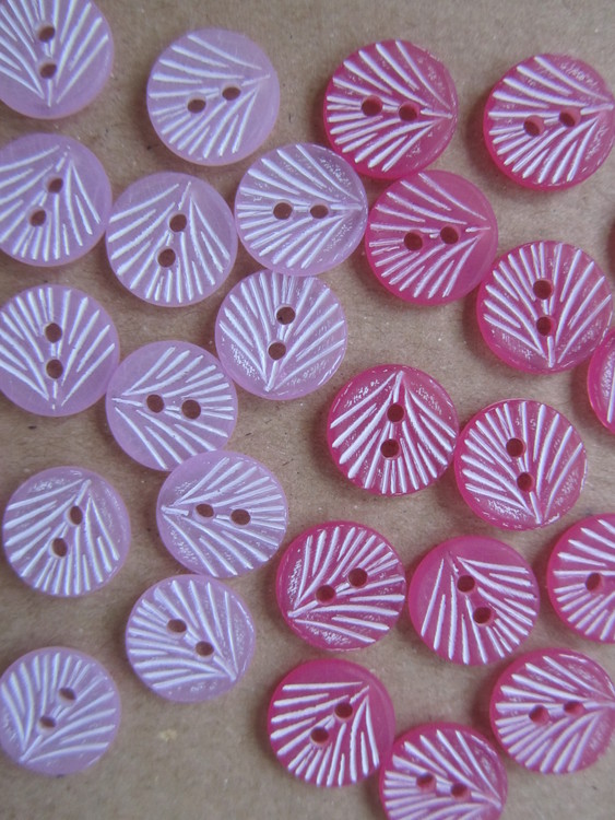 Ljuslila och rosa knapp med vitt mönster. Två hål. 12 mm.
