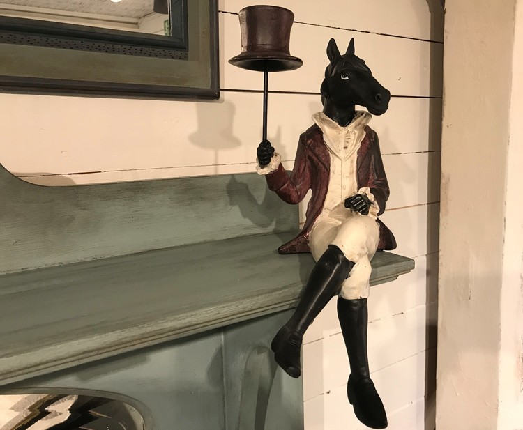 Häst med hatt sitter på en hylla eller en bordskant