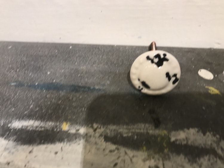 Liten vit knopp med svarta stänk