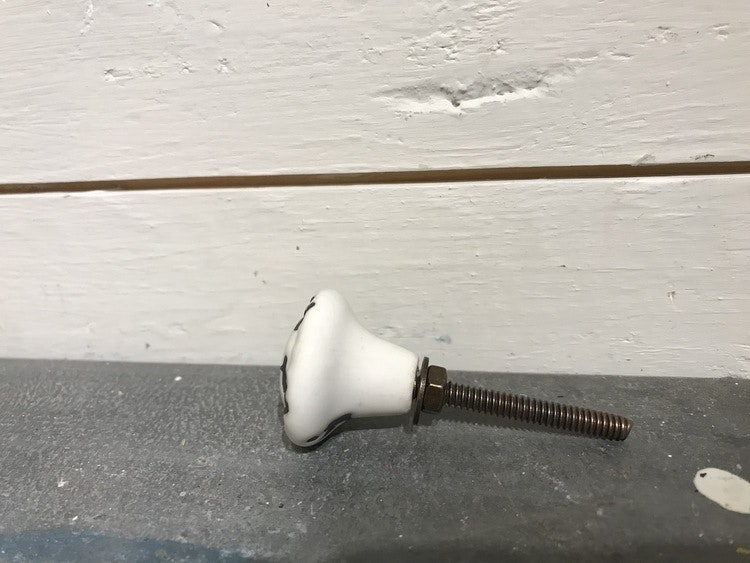 Liten vit knopp med svarta stänk