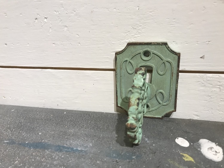 Grön metallknopp i form av en nyckel.
