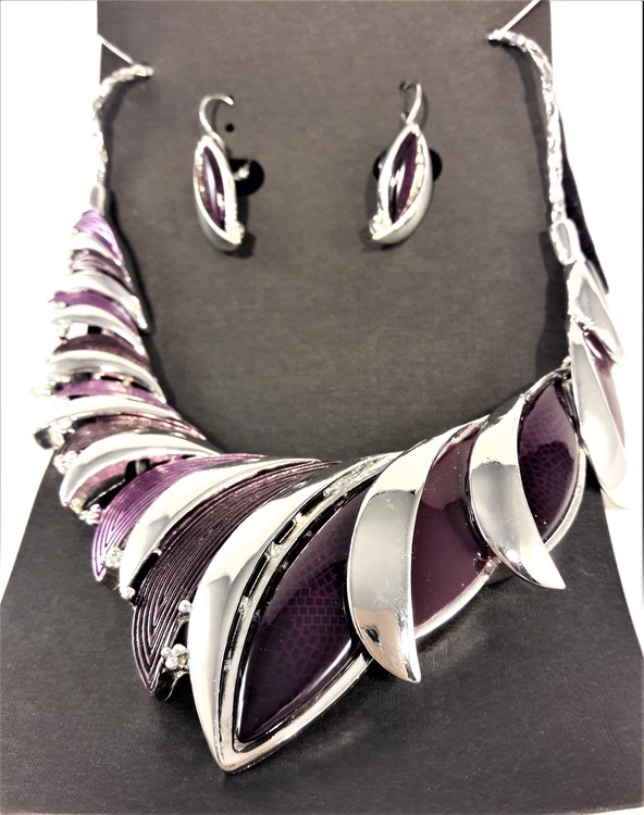 Dekorativt, tungt och vackert lyxhalsband och örhängen med vackra skimrande stenar i lila