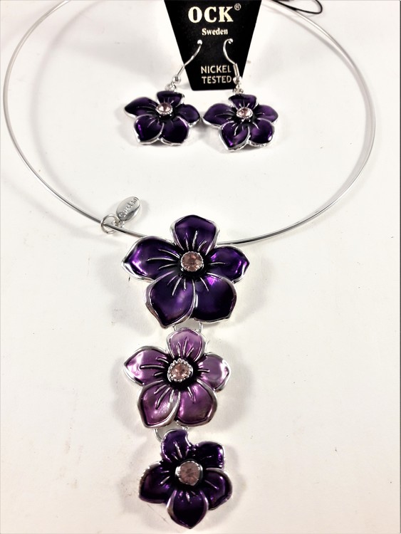 Stelt halsband med hänge av lila blommor samt matchande örhängen