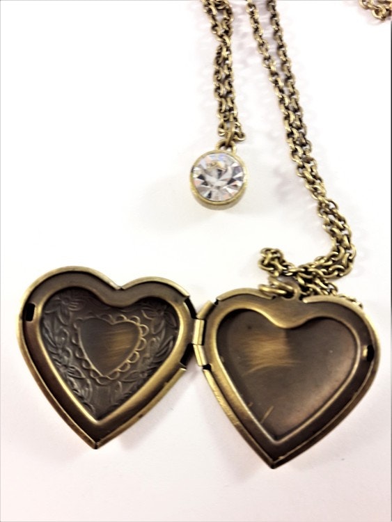 Vacker guldfärgad medaljong i kedja med glittrande sten och öppningsbart  hjärta med plats för foto - Trollania.se