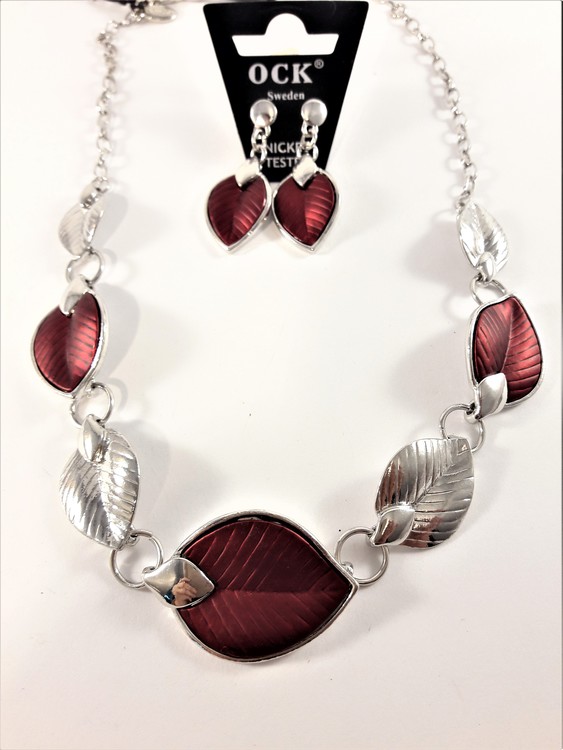 Silverfärgad halskedja med detaljer, löv i rött och silverfärg och matchande örhänge