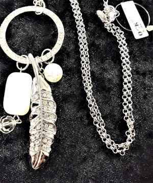 Halskedja med flera silverfärgade detaljer med gnistrande strass