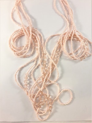 Långt flerradigt halsband med små kulor och detaljer aprikosfärg