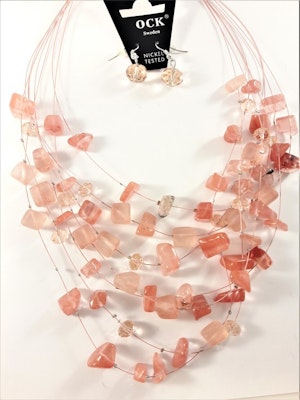 Flerradigt halsband med korallfärgade dekorationer och matchande örhängen