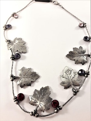 Halsband med löv i silverfärg och stenar i rött och vitt