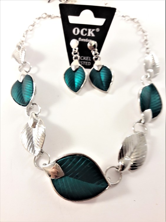 Silverfärgad halskedja med detaljer, löv i blågrönt och silverfärg och matchande örhänge