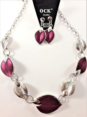 Silverfärgad halskedja med detaljer, löv i lila och silverfärg och matchande örhänge