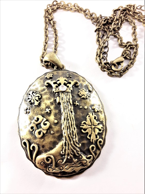 Halsband med medaljong i guldfärg och vit sten