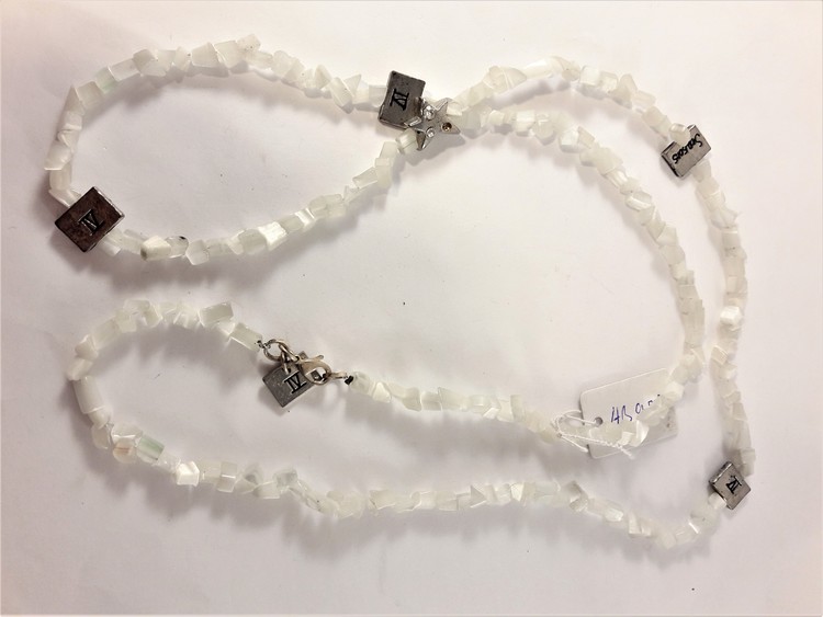 Halsband med vita stenar och silverfärgade detaljer