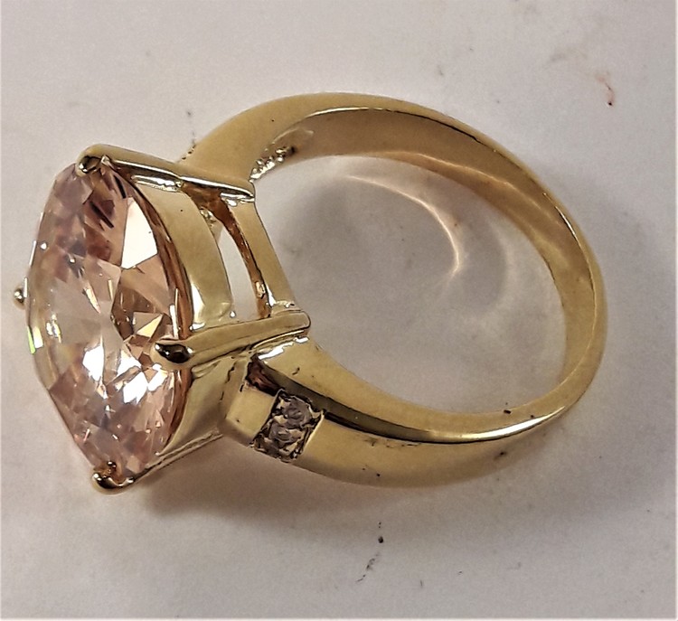 Guldfärgad ring med stor rosa gnistrande sten