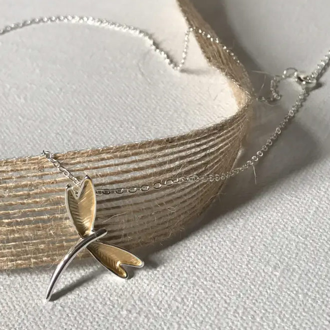 Bild på ett halsband i form av en silver- och guldfärgad trollslända