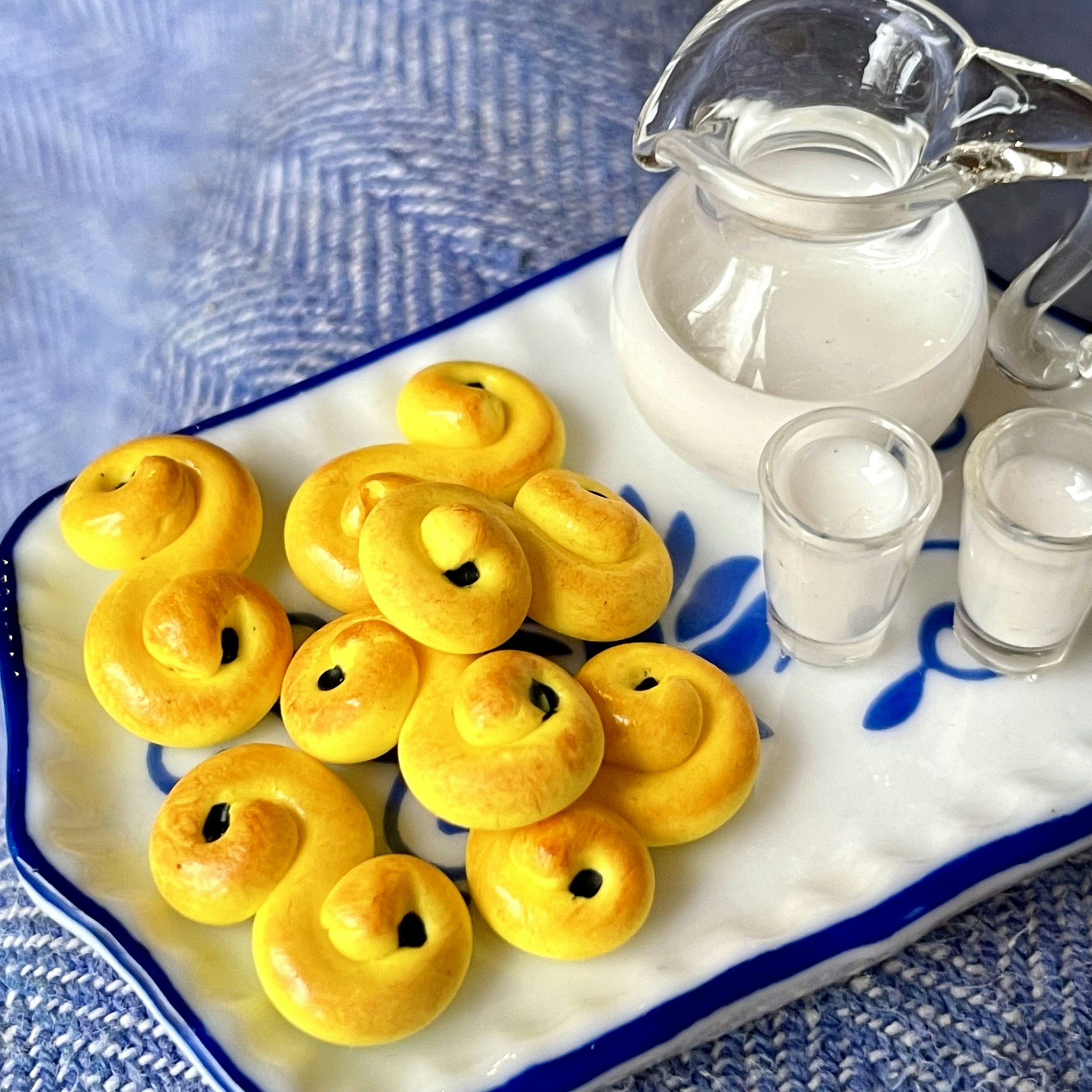 Lussekatter med mjölk på porslinsbricka