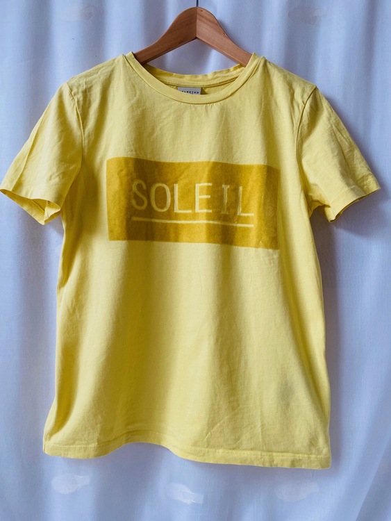Gul t-shirt med texten SOLEIL