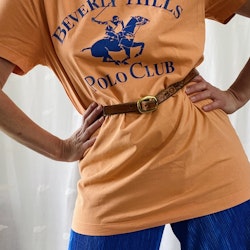 Orange t-shirt med blått tryck av polohäst