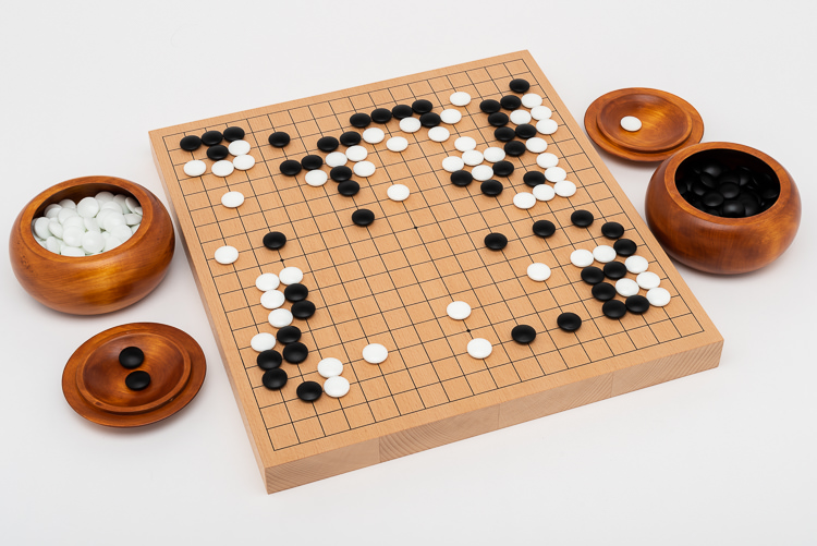 Go-spel för den seriösa spelaren; tjockt bräde med rödbruna träskålar och glasstenar