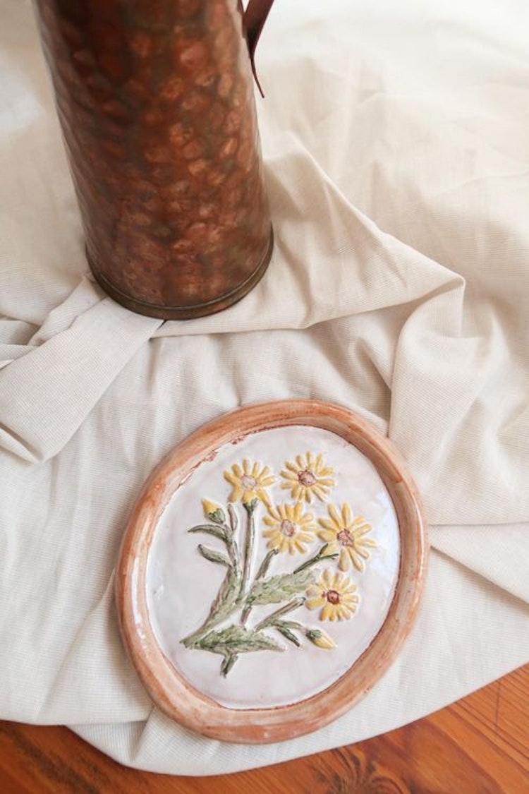 Liten keramiktavla med blommor