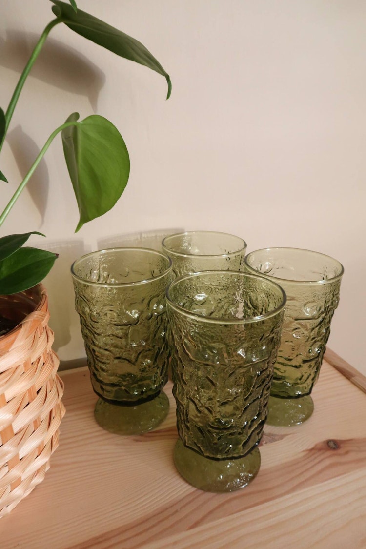 Fyra gröna glas på fot