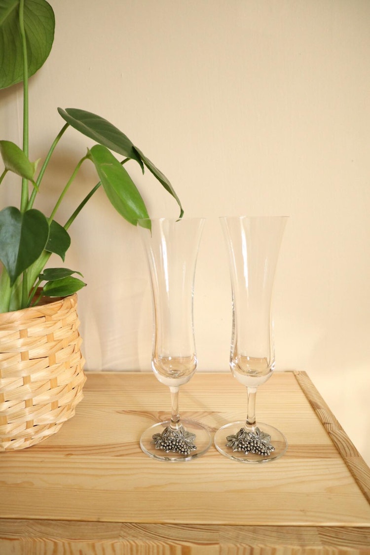 Två champagneglas med vindruvor i tenn