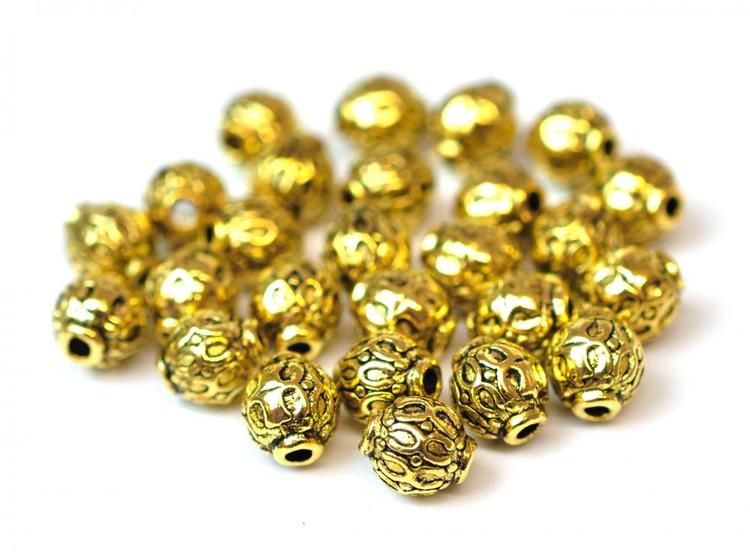 Antikt guldfärgade mönstrade små metallpärlor 6 mm, ca 10 st