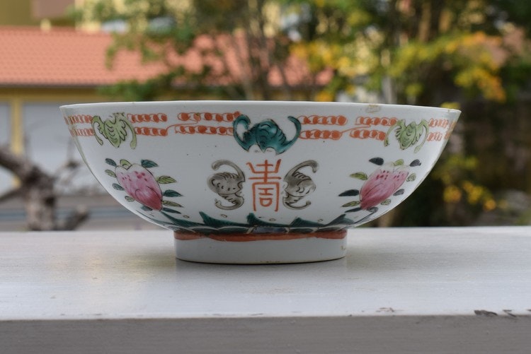 A large antique chinese bowl decorated with peach & bats Late Qing Dynasty