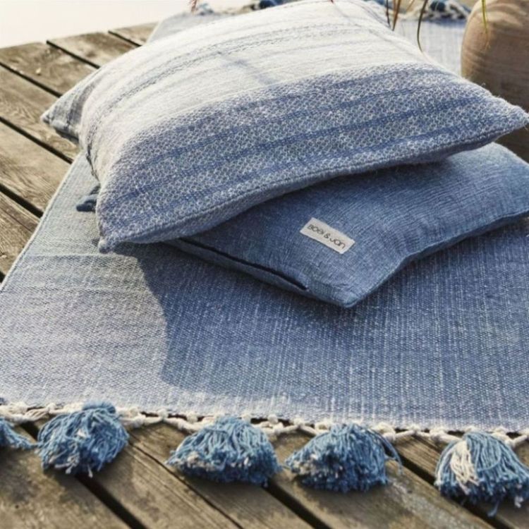 Blossom en tuff matta med tofsar istället för frans. Färg: Blå/jeansblå.