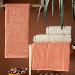 Riga en serie med beige badlakan handdukar i en tjock och slitstark bomullsfrotté från Indusia design.