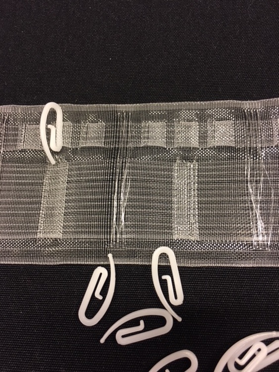 Multiband ett gardinband med tre upphängningsmöjligheter, fingerkrok, rynkbandskrok och hällor att trä stången på