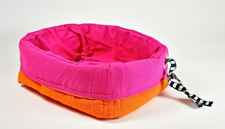 Förvaringskorg i tyg med stoppning, vändbar. Färg: Rosa och orange.