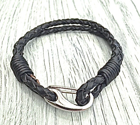 Armband med ett dubbelt flätat läderband och en karbinhake i stål. Art.nr 2023. Färg: Svart och stål.
