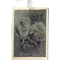 Old Santa 1 ett julhänge med en gammaldags tomtebild. Färg: Off-whithe, grått och glitter.