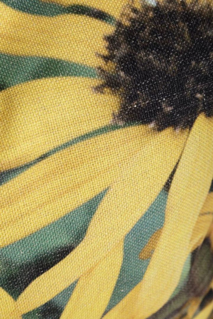 Sunflower ett grovt vävt kuddfodral från Svanefors med ett digitaltryck av gula blommor. Färg: Gula blommor på en grön botten.