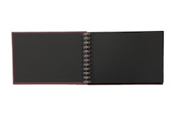Anteckningsblock/album Wire-o med vinröda pärmar och svarta sidor och spiralrygg, mått 24 x 16 cm.