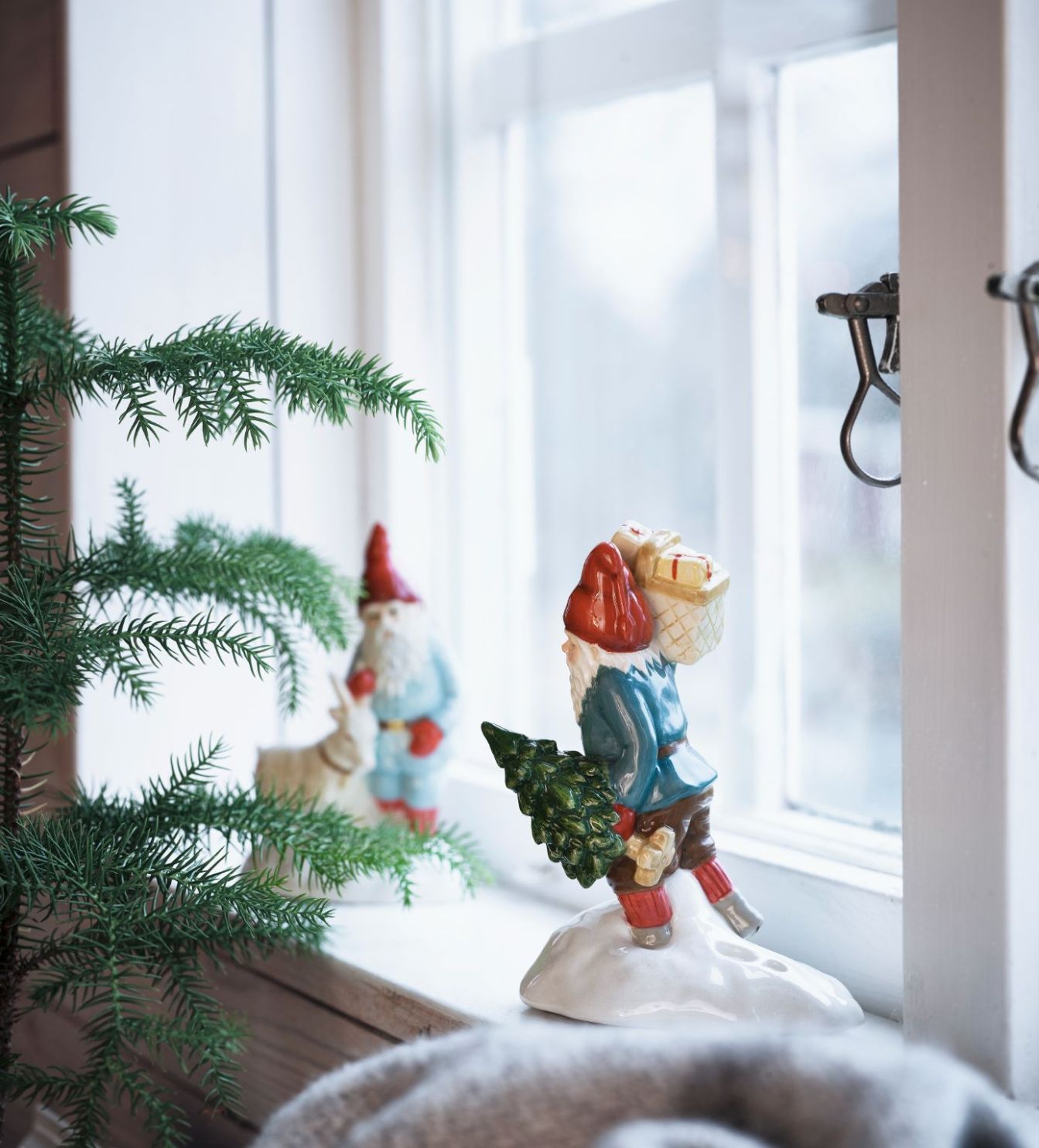Jennys julbock som har fått sin inspiration från Jenny Nyströms julkort från Cult design, en porslinsfigur i vitt, grått och rött.