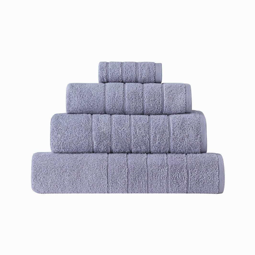 Roma ett set med 4 st lila gästhanddukar i stl 30 x 50 cm i en mysig vit frottékorg och en tvål.